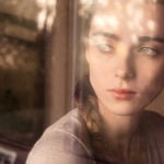 A woman is looking out of a window.