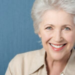 An older woman with short hair is smiling for the camera.