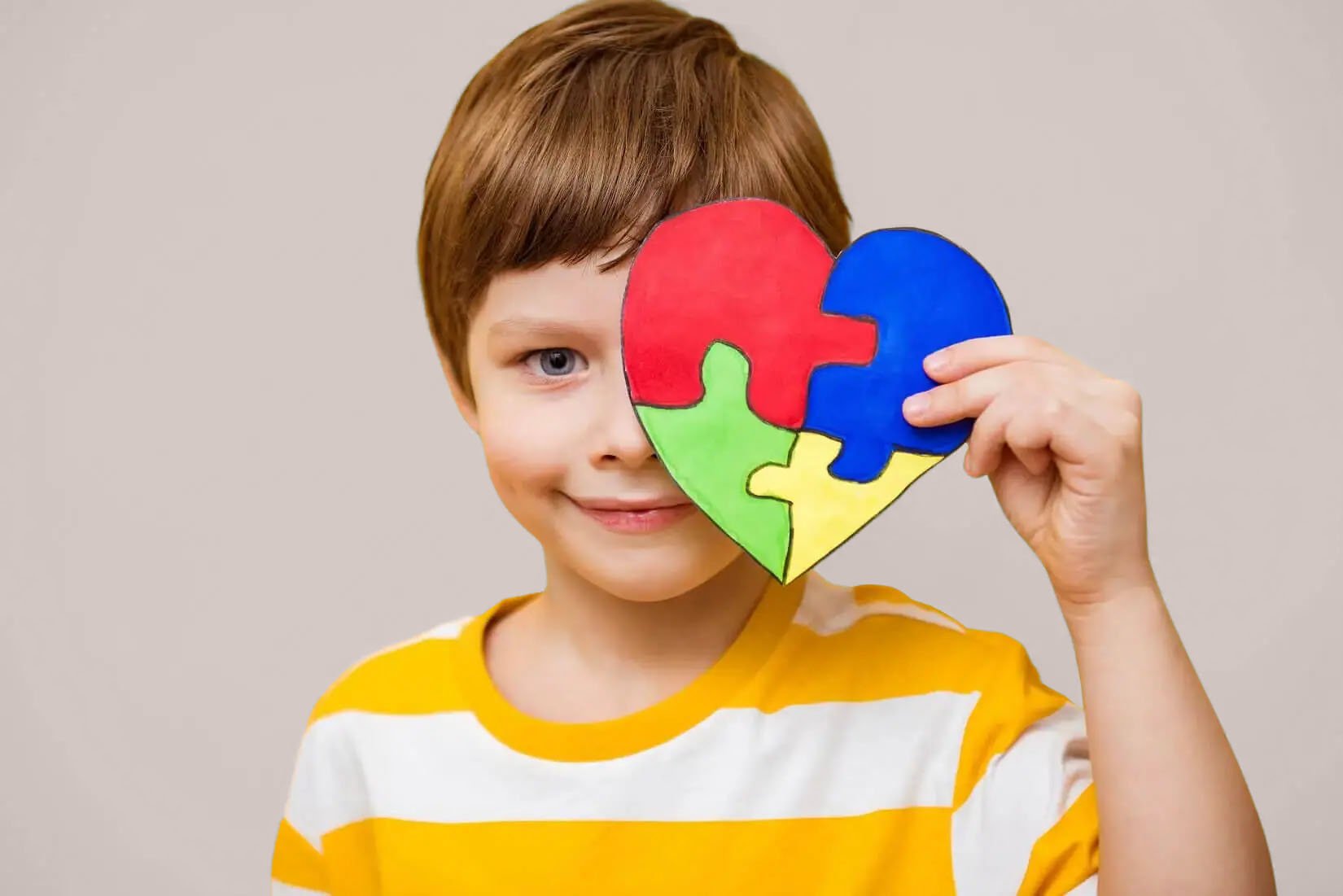 Boy-with-Austim-holding-up-a-heart-image-CHANGE-BG-COLOR-v01